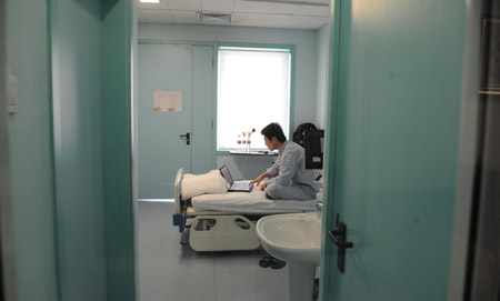An isolated patient whose surname is Qin surfs Internet at the isolation ward at the Beijing Ditan Hospital in Beijing, capital of China, May 20, 2009. [Li Wen/Xinhua]