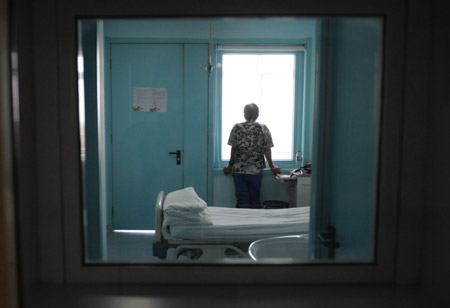 An isolated patient looks out of the window at the isolation ward at the Beijing Ditan Hospital in Beijing, capital of China, May 20, 2009. [Li Wen/Xinhua]