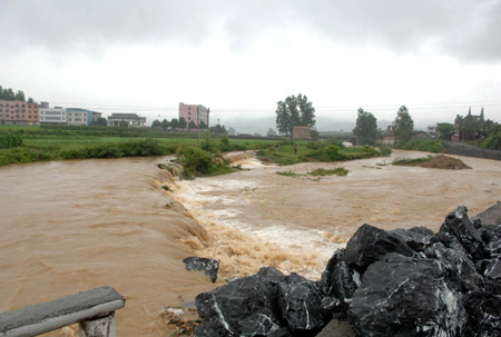 Flood water runs down the farmland near Chenzhou city, south China's Hunan province, May 20, 2009 after heavy rain swept across provinces in south China for the second day. [Xinhua] 