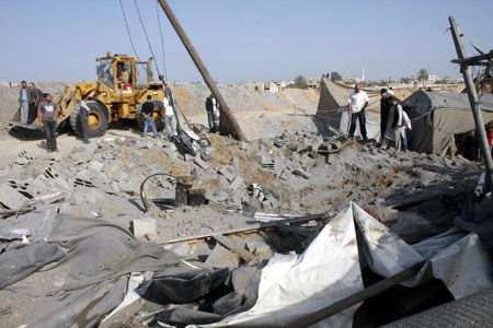 Palestinian men inspect the damaged smuggling tunnel linking the southern Gaza Strip town of Rafah with Egypt following an overnight Israeli air strike in Gaza Strip, May 20, 2009. Israeli warplanes on Tuesday night carried out a series of airstrikes on several targets in the Palestinian Gaza Strip, wounding one person and causing severe damages to two buildings, medics and witnesses said.[Xinhua]