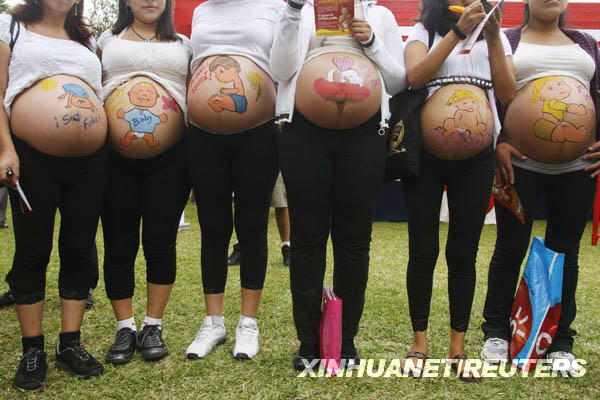 Pregnant women with their bellies painted take part in an event to celebrate 'Healthy Maternity Week' in Lima May 20, 2009. [Xinhua/Reuters] 