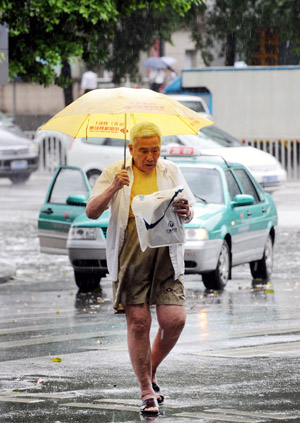 An old man holding an umbrella walks in the rain in Guangzhou, capital of south China's Guangdong Province, May 20, 2009. A rainstorm hit Guangzhou Wednesday and affected drainage system and traffic. [Chen Yehua/Xinhua] 