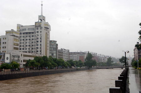 Flood water runs down a river in Chenzhou city, south China's Hunan province, May 20, 2009 after heavy rain swept across provinces in south China for the second day. Agricultural crops in some rural areas were flooded by the unexpected summer flood. [Li Xiwan/Xinhua] 