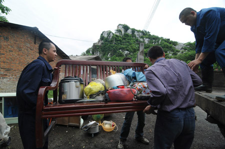 Chinese local residents collect and transfer their belongings after their residence was destroyed by rolling stones when a heavy rain hit Liuzhou city, southwest China's Guangxi Zhuang Autonomous Region, May 20, 2009. [Xinhua]