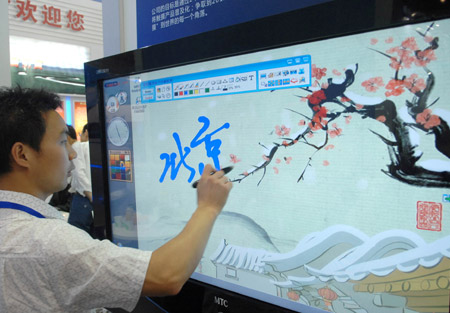A Chinese visitor makes a test writing on an electron screen at the 12th Beijing International Science and Technology Exposition held in Beijing, May 20, 2009. (Xinhua Photo)