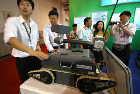 A Chinese staff shows off an explosive-proof robot at the 12th Beijing International Science and Technology Exposition held in Beijing, May 20, 2009. (Xinhua/Zhao Bing)