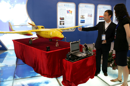 Chinese staff show off an automatic-piloted minisize airplane at the 12th Beijing International Science and Technology Exposition held in Beijing, May 20, 2009. [Xinhua/Zhao Bing]