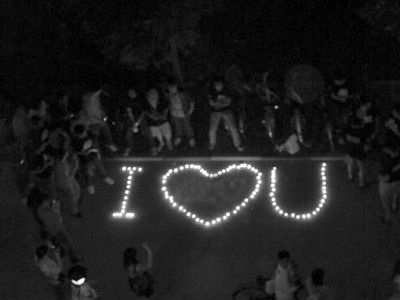 Boy students in the local university in Yangpu District in Shanghai make up a heart-shape design by lighting candles out on the evening campus under their girl classmates dorm building to show their profound friendship for them. [Photo:Shanghai Evening Post]