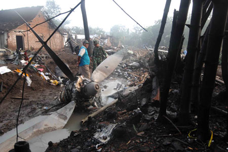 Soldiers clear the debris of the crashed airplane in Magetan, East Java province, Indonesia, on May 21, 2009. An Indonesian Air Force C-130 cargo plane crashed in Magetan on Wednesday resulting in at least 98 dead and 15 injured. [Xinhua]