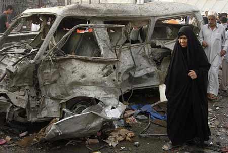 A woman walks beside a damaged vehicle at the site of a bomb attack in Baghdad's Shula district May 21, 2009. A spate of deadly bombings struck Baghdad and the northern city of Kirkuk within 24 hours on Wednesday evening and Thursday, leaving up to 65 people killed and some 145 others injured. [Xinhua/Reuters] 