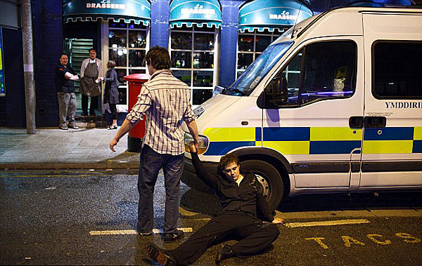 Just resting: One party-goer slumps against the wheel of a police van [Chinanews.cn]