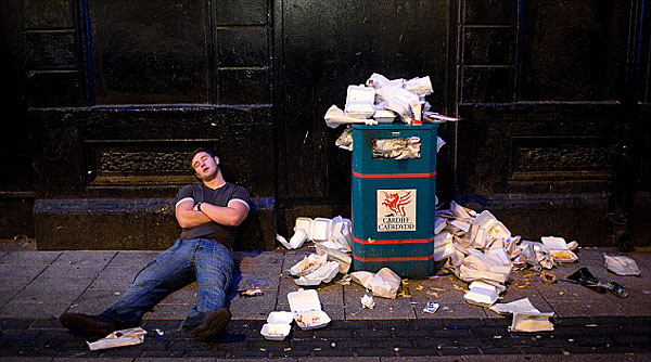 Forty winks: One man picks a spot for a nap - right next to an overflowing dustbin [Chinanews.cn]