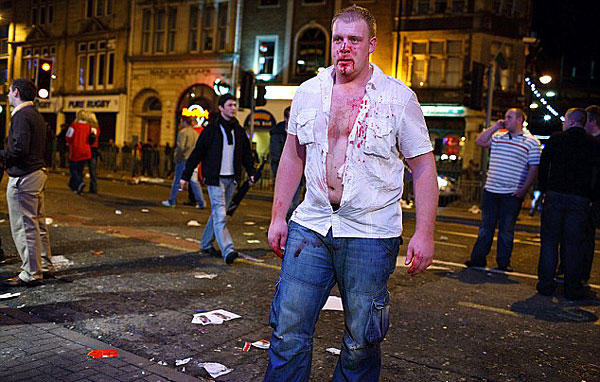 Bloodied: An injured man staggers across the street [Chinanews.cn]