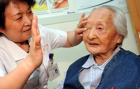 A 103-year-old senior female Li Chaolan identifies her restored eyesight by counting the doctor's finger numbers, after having undergone a successful left eye's cataract operation, at the Gucheng Ophthalmological Hospital, in Xi'an, northwest China's Shaanxi Province, May 21, 2009. [Yuan Jingzhi/Xinhua]