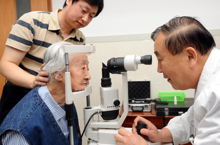  A 103-year-old senior female Li Chaolan (L, front) goes through the ocular checkup prior to her left eye's cataract operation, at the Gucheng Ophthalmological Hospital, in Xi'an, northwest China's Shaanxi Province, May 21, 2009. [Yuan Jingzhi/Xinhua]