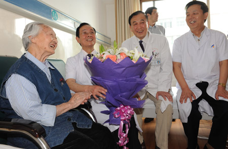 A 103-year-old senior female Li Chaolan enjoys her happiness with the medical staffs after having undergone a successful left eye's cataract operation and regained a normal eyesight, at the Gucheng Ophthalmological Hospital, in Xi'an, northwest China's Shaanxi Province, May 21, 2009. [Yuan Jingzhi/Xinhua]