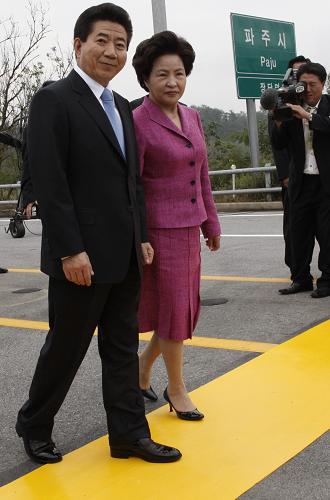 South Korean President Roh Moo-Hyun and his wife Kwon Yang-sook walk toward the border line as they head for DPRK in Paju, north of Seoul, in this October 2, 2007 file photo. South Korea's former President Roh died on May 23, 2009 after he fell while mountain hiking, Yonhap news agency quoted police as saying. 