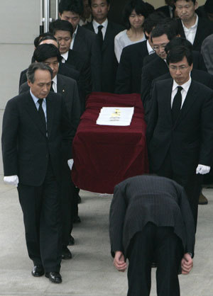 People carry a coffin containing the dead body of former South Korean President Roh Moo-hyun as a man (front) bows to Roh at a hospital in Yangsan, about 430 km (267 miles) southeast of Seoul May 23, 2009. Former South Korean President Roh Moo-hyun died of external head injury after falling down a mountain at around local time 09:30 (0030 GMT) Saturday.