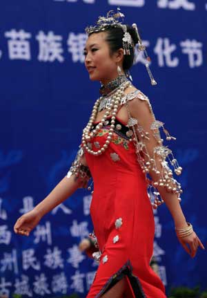 A Chinese girl of Miao ethinc minority showcases her traditional silver ornament at a gathering in Fenghuang county, central south China's Hunan province, May 23, 2009. The gathering is aimed to promote the culture of China's Miao ethnic minority, especially their tradition of wearing different designs of silver ornament. (Xinhua/Long Tao)