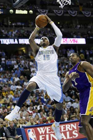 Denver Nuggets forward Carmelo Anthony goes to the basket past Los Angeles Lakers center Andrew Bynum during their NBA basketball game in Denver