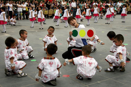 The children of a kindergarten perform group gymnastic exercise in an activity in Yuncheng, a city of north China's Shanxi Province, May 24, 2009. Over 300 children performed large scale group gymnastic exercise on Sunday to greet the upcoming Children's Day.