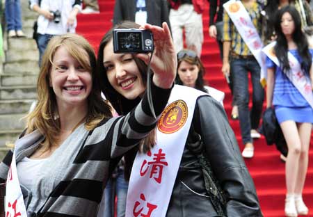 Two models shoot pictures for themselves during a showoff gathering at Yichang city in central China's Hubei province, May 23, 2009. 51 models from 48 countries and regions gathered in China's Hubei province to attend the final session of the 19th World Super Model Competition. 