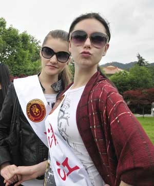 Two models pose for pictures during a showoff gathering at Yichang city in central China&apos;s Hubei province, May 23, 2009. 51 models from 48 countries and regions gathered in China&apos;s Hubei province to attend the final session of the 19th World Super Model Competition. 