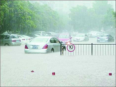 Cars capsized in a pit of water formed due to days of heavy rain in Shenzhen on Sunday. [zhnews.net]