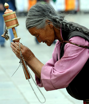 An elder woman prays in front of the Jokhang Temple in Lhasa, southwest China's Tibet Autonomous Region, while celebrating the Sakadawa Festival, May 25, 2009. The Sakadawa Festival, which begins on the First Day of the Fourth Month of the Tibetan Calendar and lasts one month, is celebrated by Tibetan Buddhists to commemorate the Buddha's birth, enlightenment and death. (Xinhua/Gesang Dawa) 