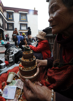 An elder buddhist nun prays in front of the Jokhang Temple in Lhasa, southwest China's Tibet Autonomous Region, while celebrating the Sakadawa Festival, May 25, 2009. The Sakadawa Festival, which begins on the First Day of the Fourth Month of the Tibetan Calendar and lasts one month, is celebrated by Tibetan Buddhists to commemorate the Buddha's birth, enlightenment and death. (Xinhua/Gesang Dawa) 