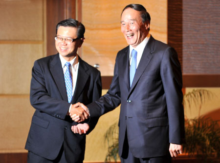 Chinese Vice Premier Wang Qishan (R) shakes hands with Singapore's Deputy Prime Minister Wong Kan Seng during their meeting in Suzhou, east China's Jiangsu Province, on May 25, 2009.