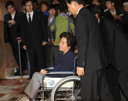 Kwon Yang-sook, wife of deceased former South Korean President Roh Moo-hyun, arrives on a wheelchair to attend the rites of placing the body of the late President into a coffin in his hometown in Bonghwa village, Gimhae, about 450 km (280 miles) southeast of Seoul, early May 25, 2009. 