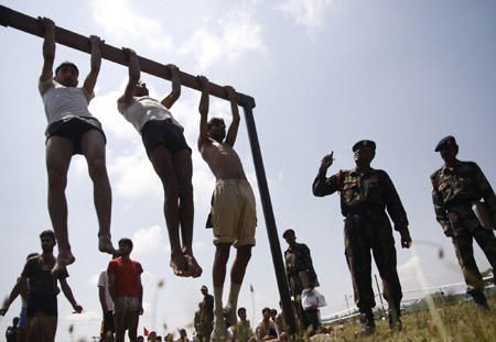 Kashmiri youths do pull-ups during a recruitment rally of the Indian army on the outskirts of Srinagar, summer capital of India-controlled Kashmir, on May 26, 2009. Around 9,000 Kashmiri youths turned up for the recruitment rally, according to an Indian army spokesperson. (Xinhua/Javed Dar)