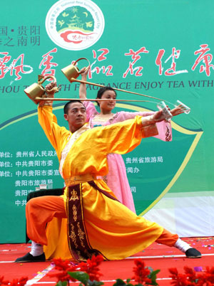 Two performers show their acrobatic skill of pouring water with a long spout into a glass at the opening ceremony of the Enjoying Fragrant Tea with Health in Guiyang, southwest China's Guizhou Province, May 26, 2009. The 5-day activity will feature art performance related to tea culture.