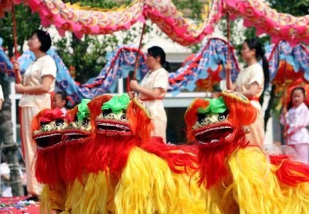 Chinese folk artists perform lion dance to mark the Duanwu Festival, also known as the Dragon Boat Festival, in Baoshan, east China's Shanghai Municipality, May 28, 2009. The Duanwu Festival falls on May 5 of Chinese lunar calendar. This year's Duanwu festival falls on Thursday.It is generally believed that the Duanwu Festival is marked to remember to Qu Yuan, one of the greatest ancient Chinese poets who drowned himself in the Miluo river to protest the corrupt court.