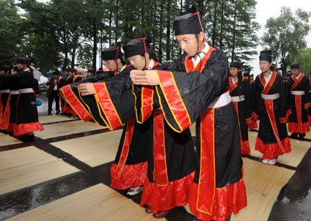 Students who study Chinese national culture worship during a commemorative ceremony for Qu Yuan, the venerable patriotic poet of the Chu State in the Warring States Period (476 - 221 BC), in Wuhan, capital of central China's Hubei Province, May 28, 2009. 