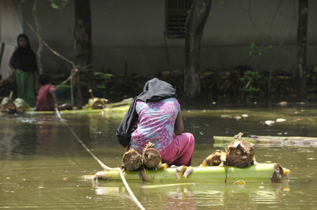 People raft in the floodwaters in Khulna, southwestern Bangladesh, on May 28, 2009. At least 131 people died and 1,123 people are still missing after the cyclone Aila hit Bangladesh's southwestern coast on Monday, officials said on Thursday.