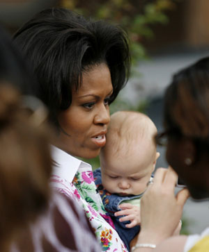 U.S. first lady Michelle Obama holds 5-month-old Sarah Lydia McCoyer while visiting students at Bancroft Elementary School in Washington May 29, 2009.