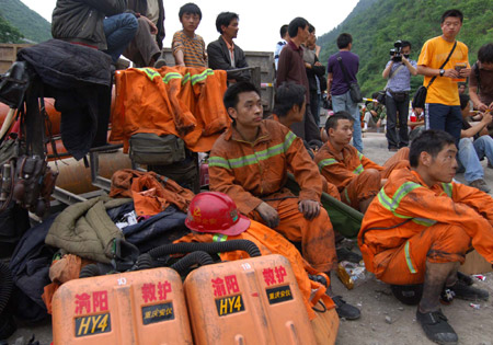 Rescuers wait at the entrance to a coal mine where a colliery gas burst at Tonghua Coal Mine in southwest China's Chongqing Municipality, on May 30, 2009. The accident has killed 30 and injured 59 miners.