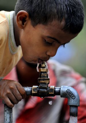 A child drinks water at a slum in New Delhi, India, on May 29, 2009. The Oscar-winning film 