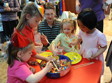 Children from China and other countries learn to use chopsticks at the site of Chinese mission to the European Union (EU) in Brussels, capital of Belgium, May 30, 2009. As the International Children's Day is coming, the Chinese mission to the European Union organized series activities with Chinese feature for children living in Brussels. [Xinhua photo]