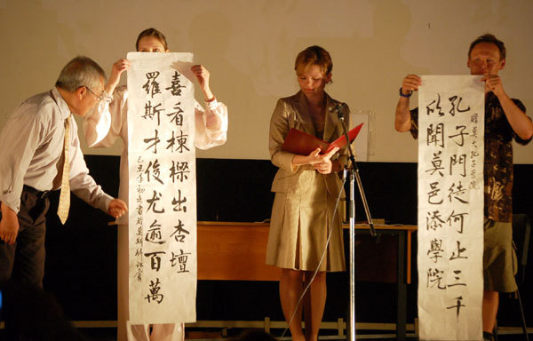 Shen Wenfu (L), a Chinese calligraphy lover living in Russia, explains the couplet he wrote for the Confucius Institute of Moscow State University, on May 30, 2009. [Photo: CRIENGLISH.com]