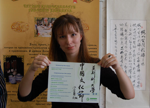 A student from the Confucius Institute of Moscow State University shows the inscription by Shen Wenfu, a Chinese calligraphy lover living in Russia, at the Chinese Cultural Festival in Moscow, May 30, 2009. [Photo: CRIENGLISH.com]