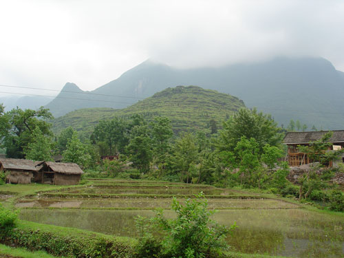 Village at the foot of a cloud-shrouded peak