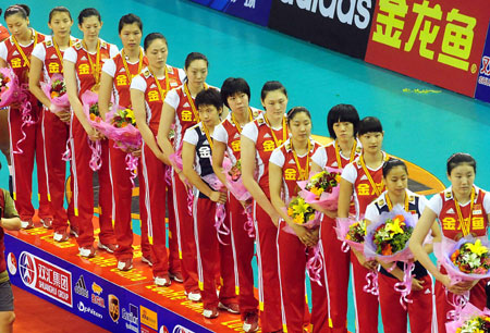 Chinese team members hold flowers in the awarding ceremony after winning over Cuba during a match at the 2009 Chinese Women's Volleyball Tournament in Luohe, a city of central China's Henan Province, May 31, 2009. China beat Cuba 3-0, and got the champion of the tournament with all victories. (Xinhua/Wang Song) 