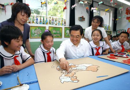 Chinese President Hu Jintao (C) joins pupils to form a map of China with eggshells at Jushan Primary School in the Haidian District of Beijing, capital of China, May 31, 2009, one day ahead of the International Children's Day. (Xinhua/Lan Hongguang)