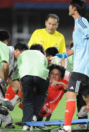China's Du Wei (C) is injured during the friendship soccer match between the national teams of China and Iran in Qinhuangdao, a city in north China's Hebei Province, June 1, 2009. China won 1-0. (Xinhua/Yang Shiyao)
