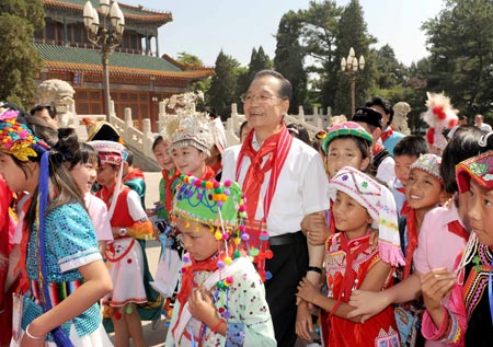 Chinese Premier Wen Jiabao (C) leads the children for a tour of the Zhongnanhai leadership compound during a celebration of the International Children's Day in Beijing, capital of China, June 1, 2009. (Xinhua/Ma Zhancheng) 