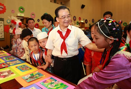 Chinese Premier Wen Jiabao (C) views the children's drawings during a celebration of the International Children's Day in Beijing, capital of China, June 1, 2009. (Xinhua/Pang Xinglei) 