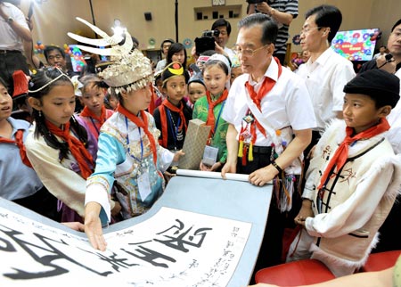 Chinese Premier Wen Jiabao (2nd R Front) receives a calligraphy work presented by a child during a celebration of the International Children's Day in Beijing, capital of China, June 1, 2009. (Xinhua/Ma Zhancheng)